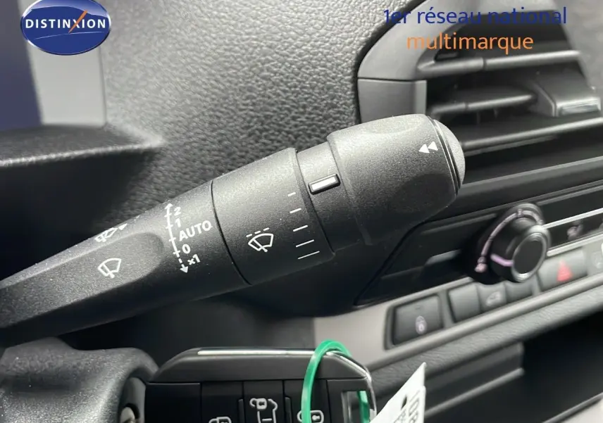 Gros plan sur la commande d'essuie-glace à gauche du volant du Peugeot Expert Fourgon blanc, intérieur noir.