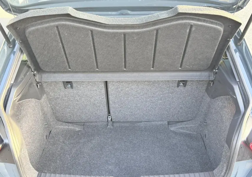 Coffre ouvert de la SEAT Ibiza TSI 115 Xcellence bleu Fjord, vue arrière montrant l'espace de chargement vide.