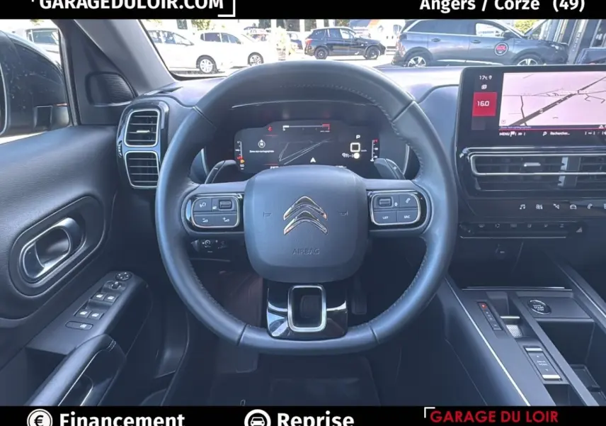 Vue intérieure centrée sur le volant cuir et tableau de bord numérique du Citroën C5 Aircross noir 2025.