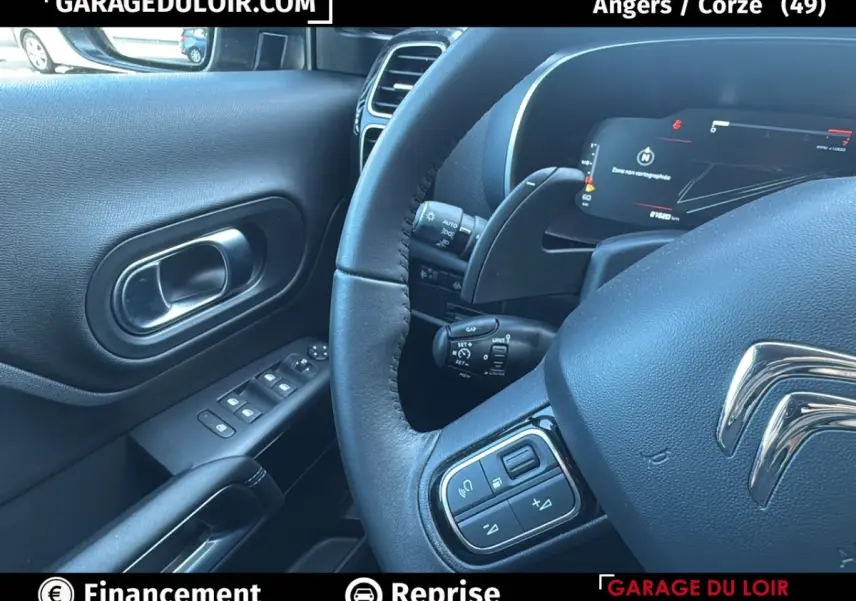 Intérieur noir du Citroën C5 Aircross 2025, vue sur le volant cuir et le tableau de bord numérique côté conducteur.