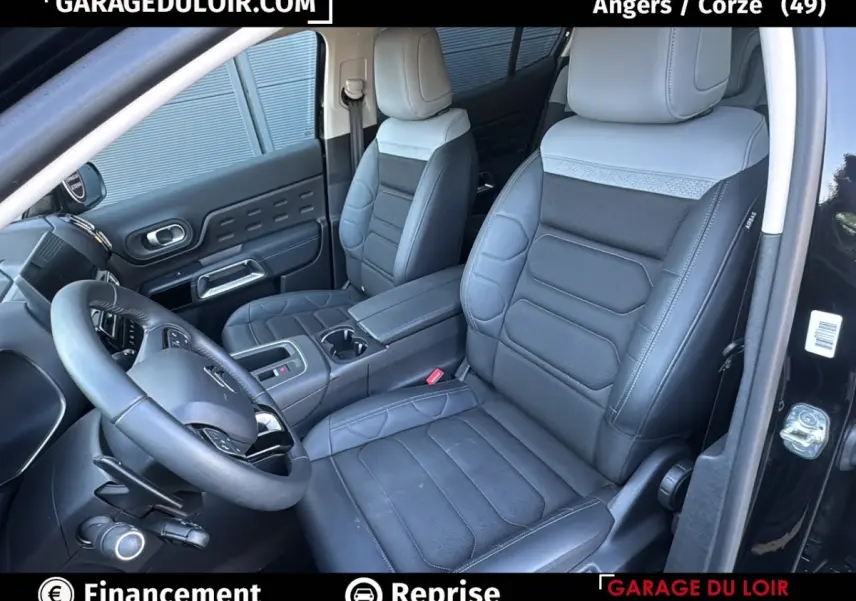 Vue intérieure côté conducteur du Citroën C5 Aircross noir 2025, sièges cuir bicolores et volant multifonctions.