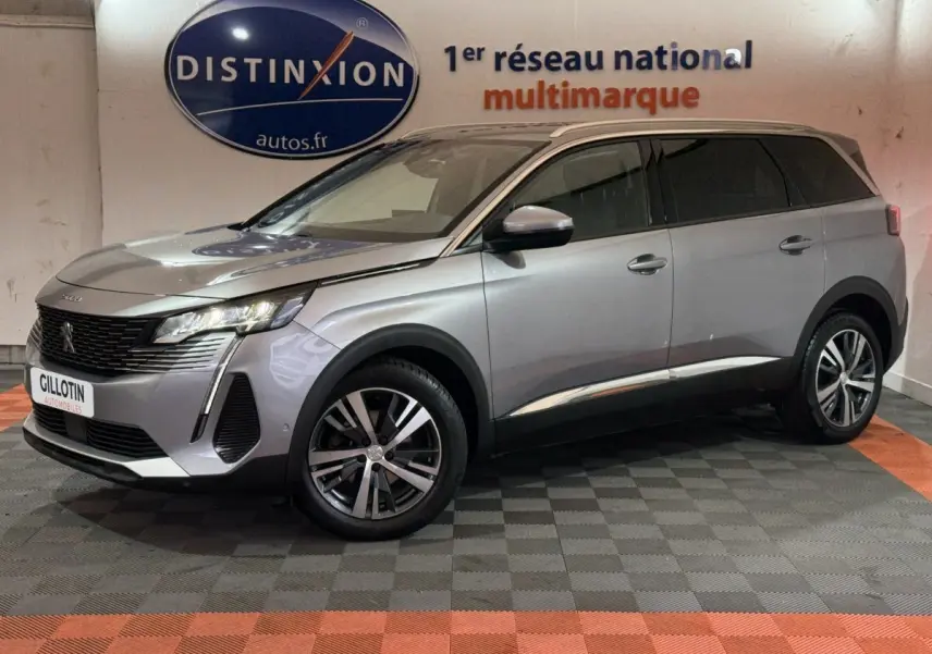 Peugeot 5008 gris clair vue de côté droit en intérieur, mettant en valeur ses phares LED et jantes alliage.