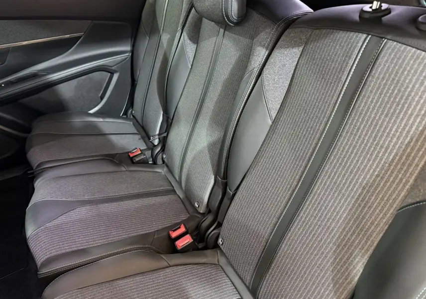 Vue latérale des sièges arrière gris tissu et cuir du Peugeot 5008, version Allure Pack 2021, avec ceintures rouges visibles.