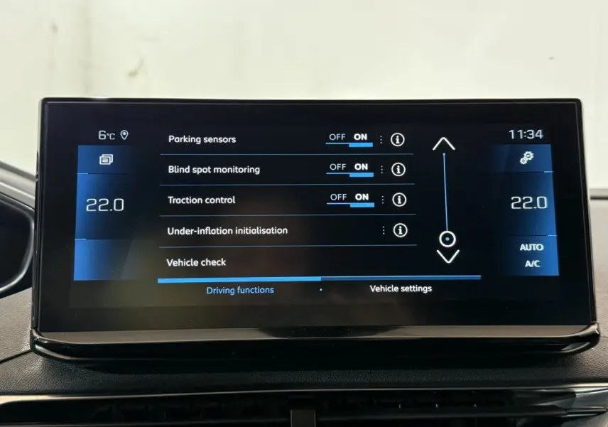 Écran tactile central du Peugeot 5008 gris clair affichant les réglages d’aide à la conduite et climatisation.