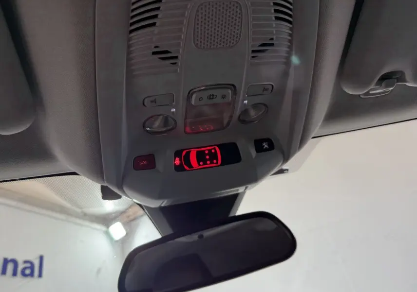 Vue intérieure du plafonnier avec commandes et affichage lumineux rouge dans un Peugeot 5008 gris clair de 2021.