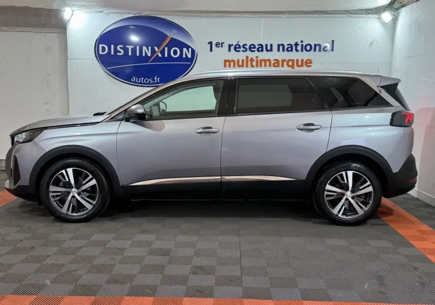 Vue de profil côté gauche d'un Peugeot 5008 gris clair, SUV avec jantes alliage et vitres teintées.