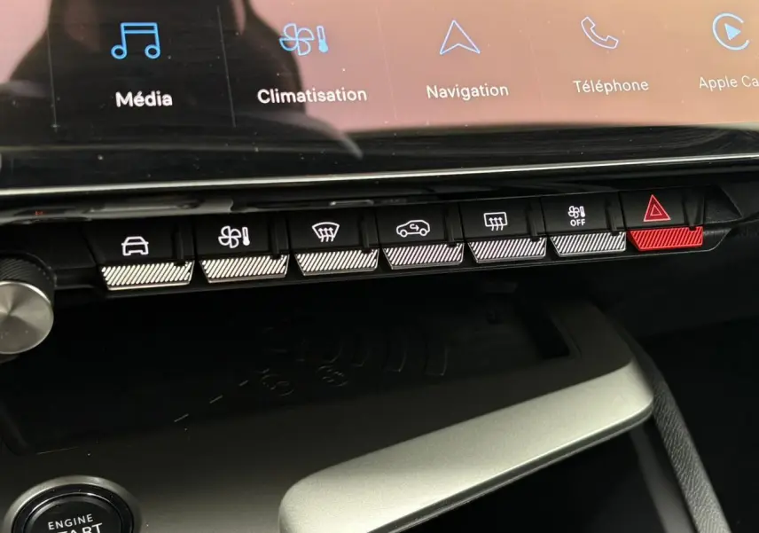 Gros plan sur la console centrale de la Peugeot 308 SW Hybrid 2025, avec écran tactile et boutons de commande lumineux.