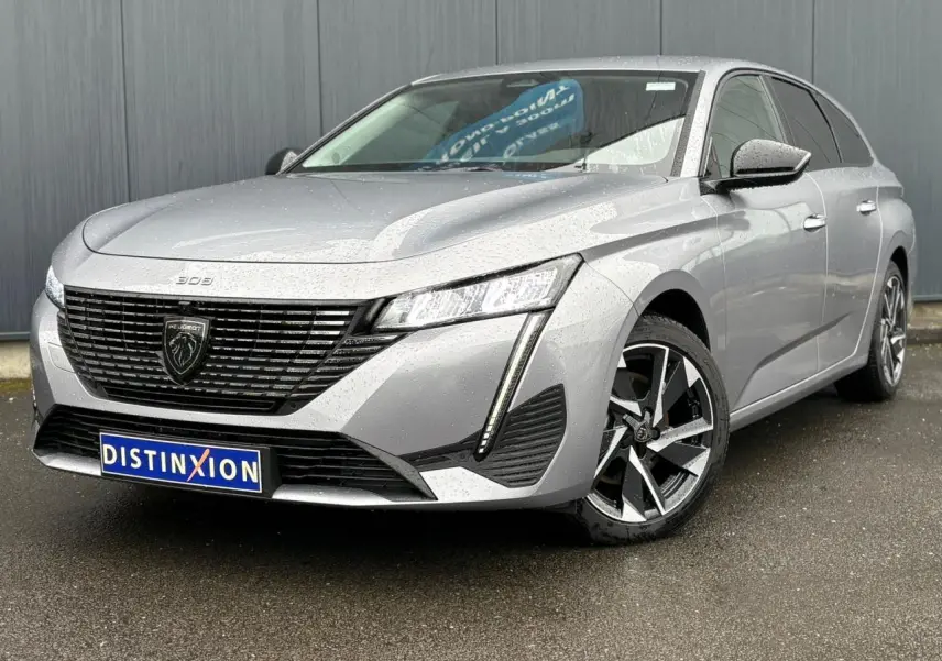 Peugeot 308 SW Hybrid gris Artense vue 3/4 avant droit avec calandre noire et jantes alliage 17 pouces.