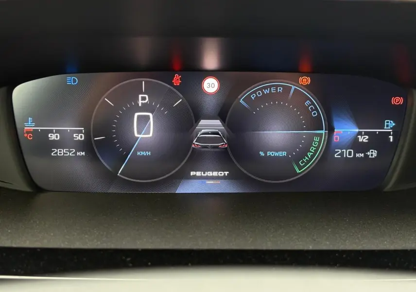 Tableau de bord numérique de la Peugeot 308 SW Hybrid 2025 affichant vitesse, autonomie et indicateurs d'énergie.
