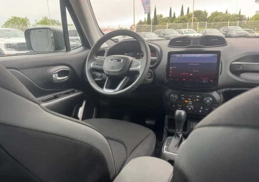 Intérieur du Jeep Renegade 2024 vu côté conducteur, volant multifonction et écran tactile central visibles.