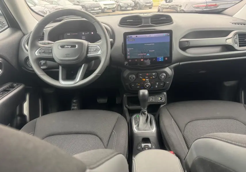 Vue intérieure avant du Jeep Renegade 2024 avec tableau de bord noir, écran tactile GPS et volant multifonction.