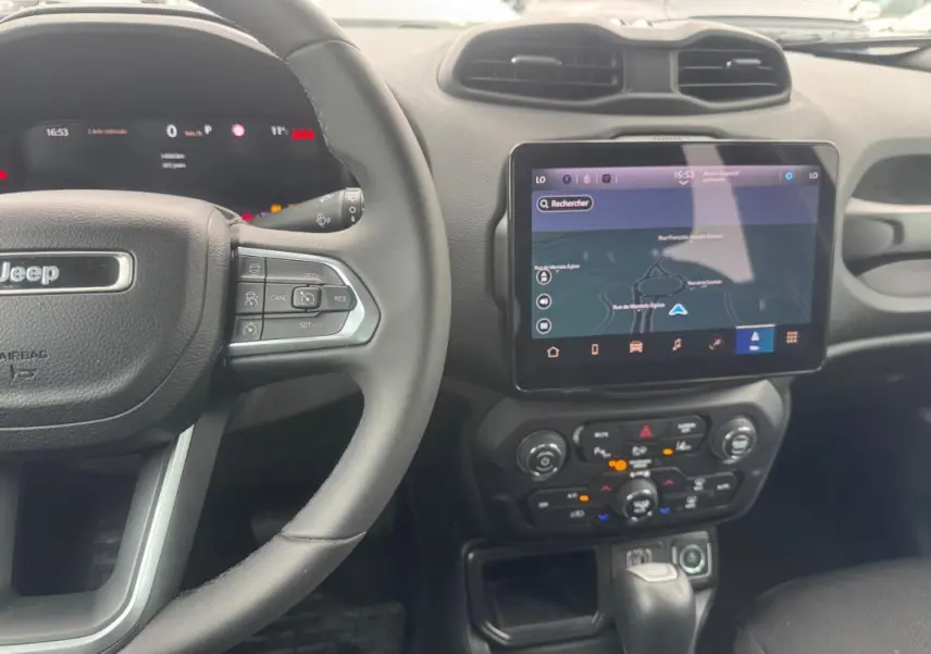 Vue intérieure centrée sur le volant Jeep et l’écran tactile GPS du tableau de bord du Renegade bleu 2024.