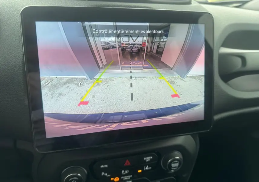 Écran tactile intérieur montrant la caméra de recul du Jeep Renegade bleu, avec guidage de stationnement visible.