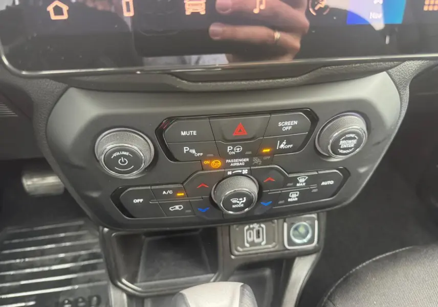 Vue rapprochée du tableau de bord et console centrale de la Jeep Renegade 2024, avec commandes climatisation et multimédia.