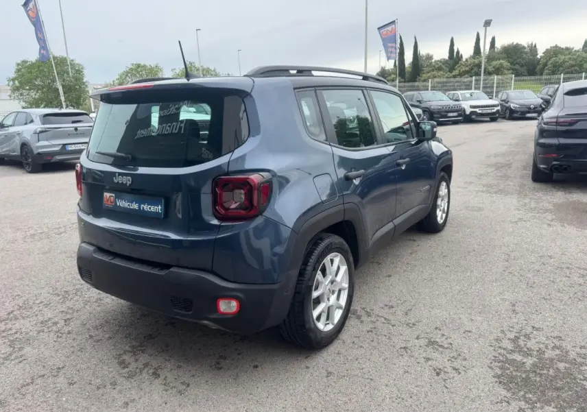 Jeep Renegade bleu vue 3/4 arrière droit, avec barres de toit et jantes alliage 17 pouces visibles.