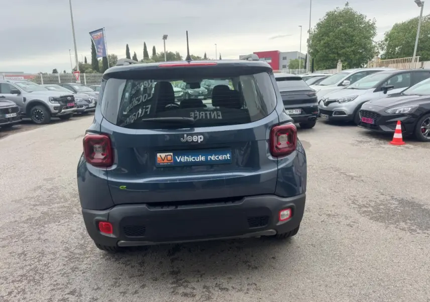 Vue arrière d’un Jeep Renegade bleu 2024 avec feux carrés caractéristiques et logo Jeep visible.