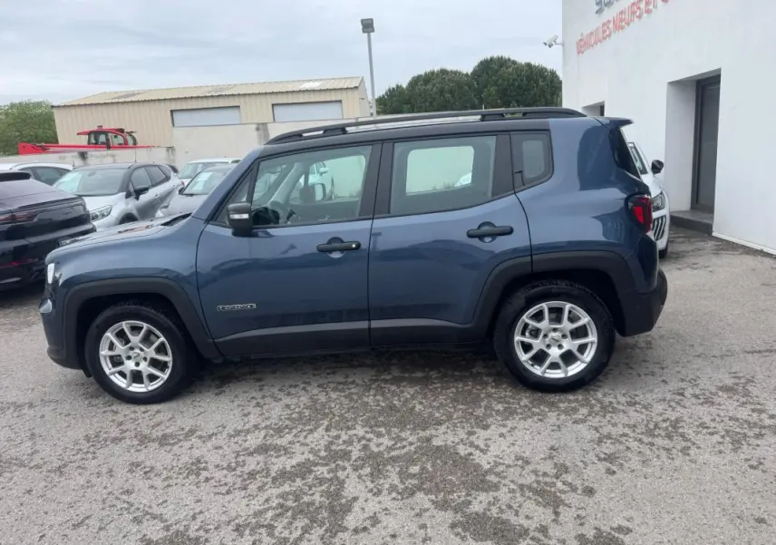 Vue de profil côté gauche d'un Jeep Renegade bleu 2024 avec barres de toit et jantes alliage 17 pouces.