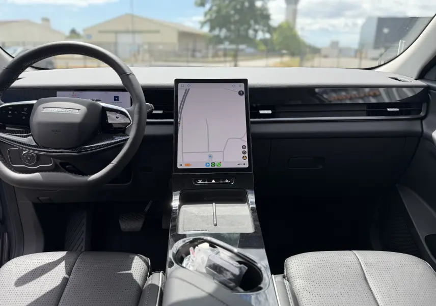 Vue intérieure avant du JAECOO J5 2026 en gris, avec grand écran tactile vertical et volant multifonction noir.