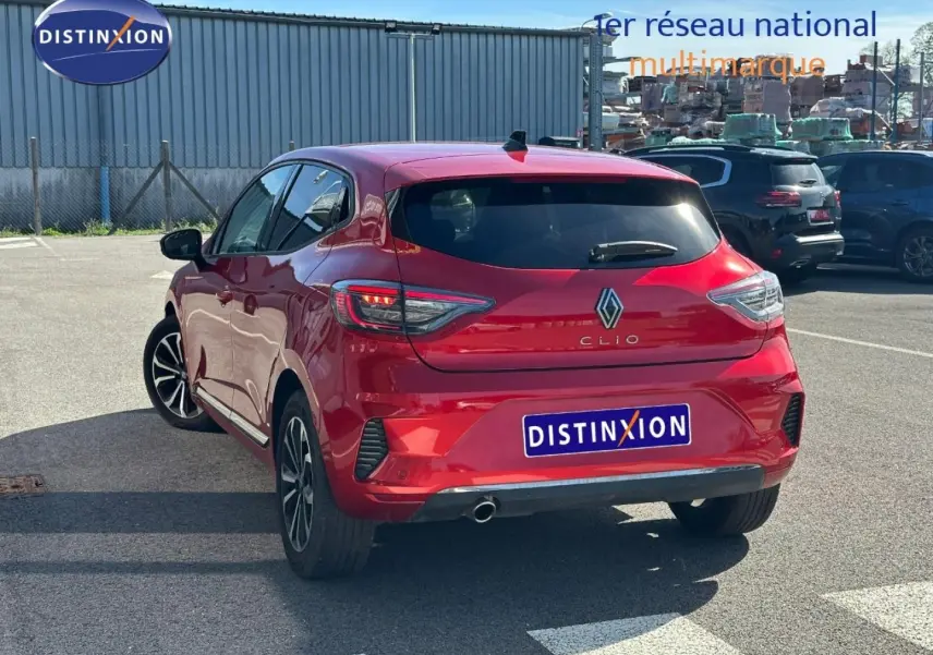 Vue 3/4 arrière droite d'une Renault Clio rouge flamme avec feux arrière LED et jantes alu.