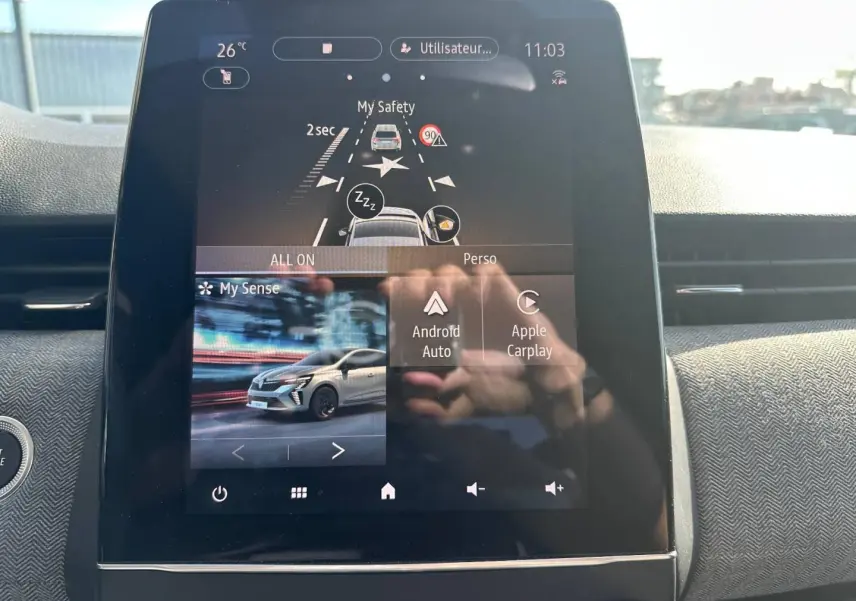 Écran tactile central affichant les aides à la conduite et connectivité Android Auto/Apple Carplay dans Renault Clio rouge Flamme 2025.