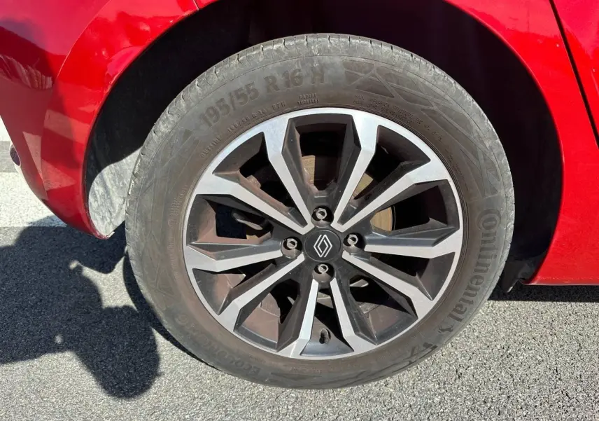 Gros plan sur la roue avant gauche d’une Renault Clio Rouge Flamme avec jante alu au design moderne.