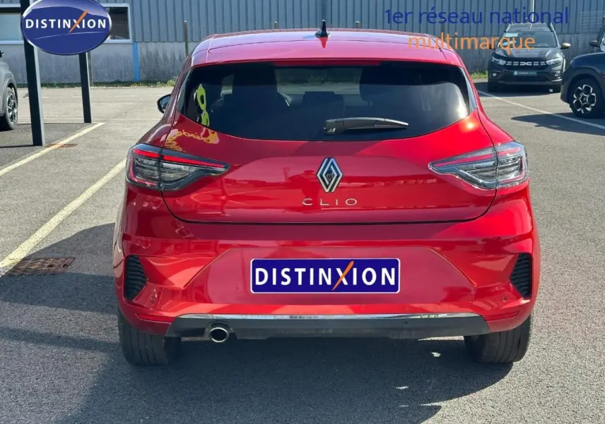 Vue arrière d'une Renault Clio rouge Flamme 2025 avec feux LED et sortie d'échappement chromée visible.