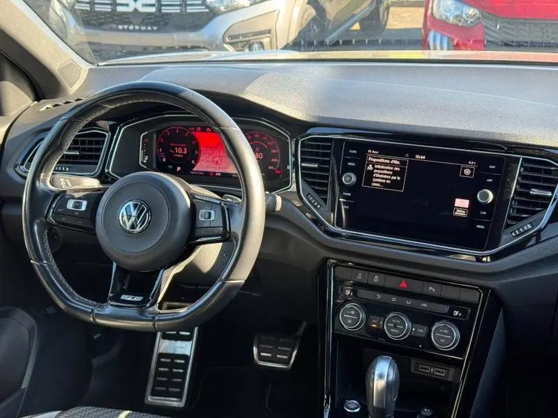 Vue intérieure avant du Volkswagen T-Roc 2.0 TSI 300ch R, volant cuir multifonction et écran tactile central.