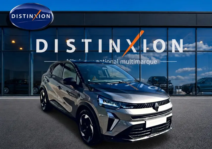 Renault Captur gris cassiopée en 3/4 avant droit, avec calandre moderne et jantes alu noires devant showroom Distinxion.
