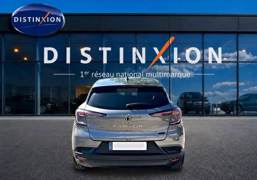 Vue arrière d'un Renault Captur gris cassiopée 2026, avec feux LED et logo distinctif sur fond de vitrine Distinxion.