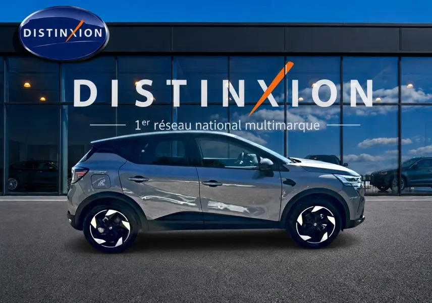 Profil droit du Renault Captur gris cassiopée 2026 stationné devant une vitrine Distinxion.