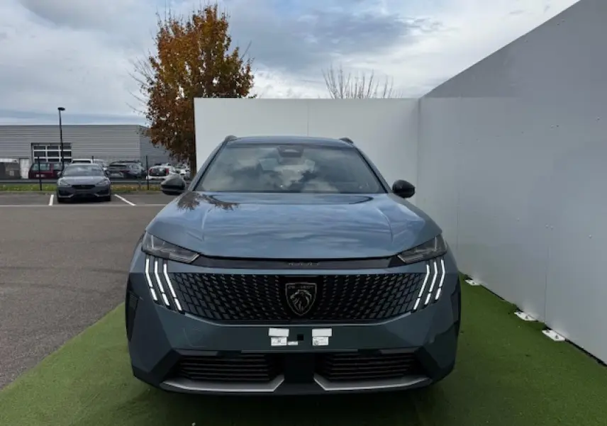 Vue frontale du Peugeot 5008 bleu Ingaro avec calandre noire et feux LED à griffes distinctifs allumés
