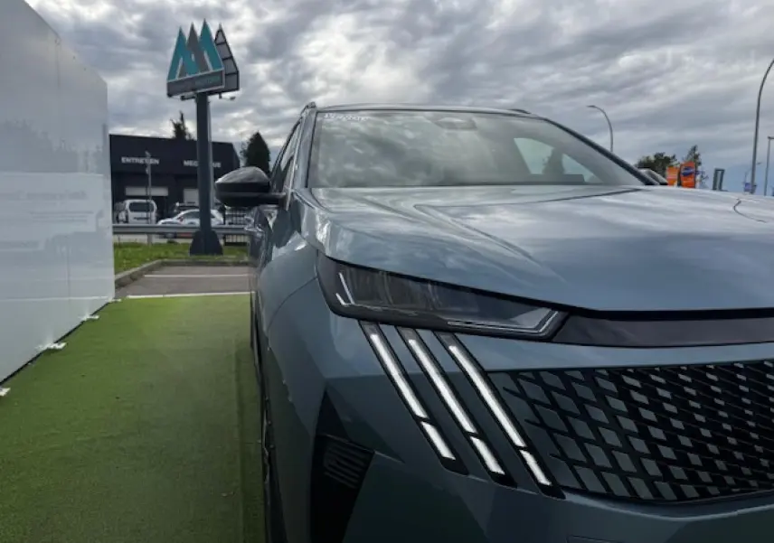 Vue 3/4 avant gauche du Peugeot 5008 bleu Ingaro avec phares LED et calandre noire texturée.