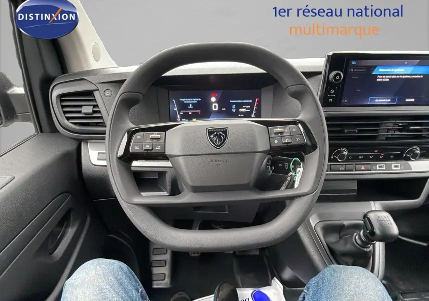 Vue intérieure centrée sur le volant et le tableau de bord du Peugeot Expert Fourgon blanc avec boîte manuelle.
