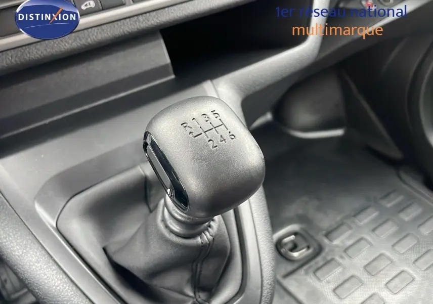 Gros plan sur le levier de vitesses manuel noir du Peugeot Expert Fourgon blanc, intérieur côté conducteur.