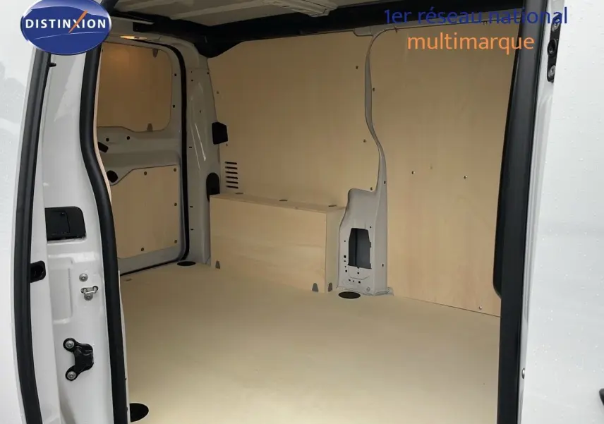 Intérieur du fourgon blanc Peugeot Expert M 1.5 BlueHDi 120ch vu de la porte latérale ouverte, avec aménagement bois clair.