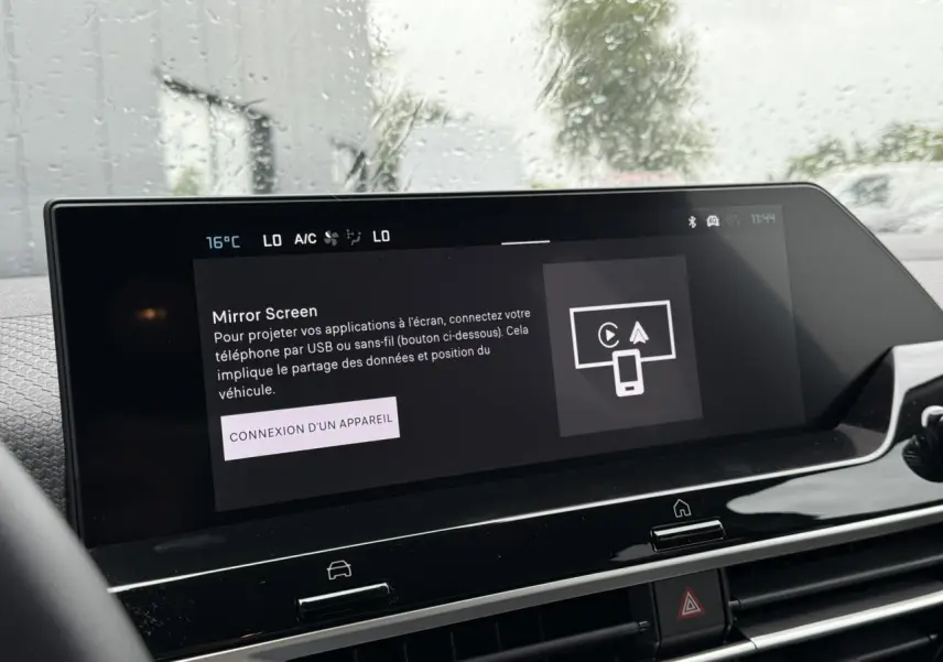 Écran tactile central de la Citroën C4 hybride 2025 affichant la fonction Mirror Screen sous pluie extérieure.