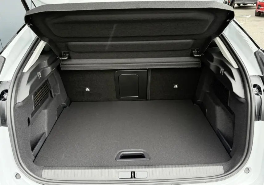 Coffre ouvert vu de l'arrière d'une Citroën C4 blanc Okénite, montrant un espace de chargement propre et spacieux.