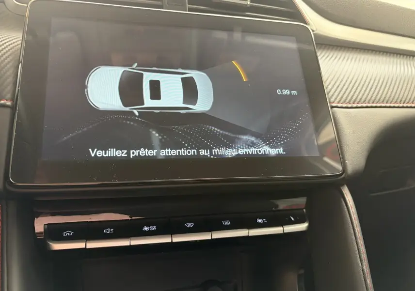 Écran tactile central du MG ZS 2022 affichant l’aide au stationnement avec interface en 3D, intérieur noir et surpiqûres rouges.