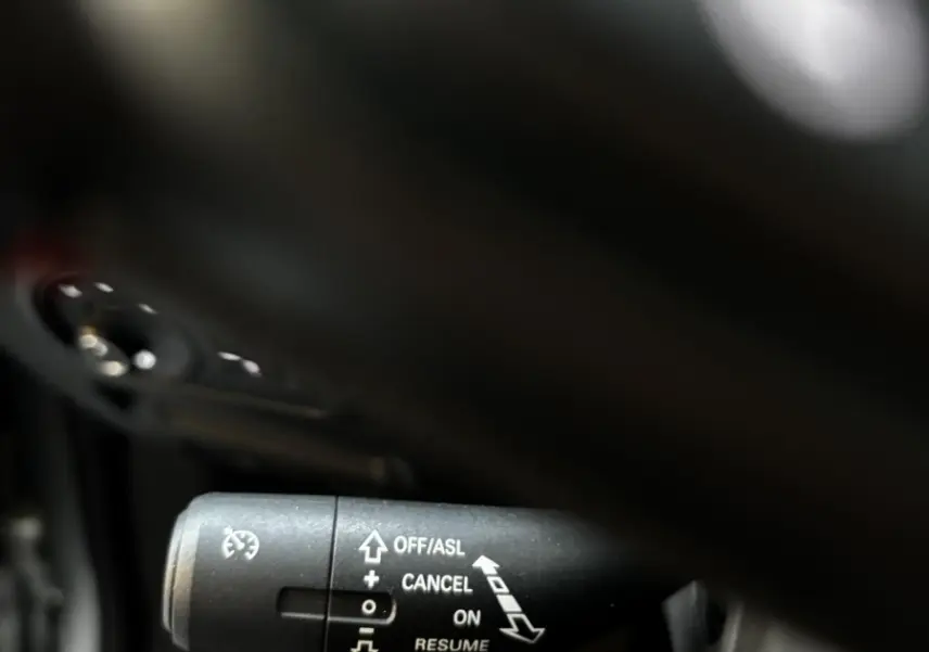 Gros plan sur la commande de régulateur de vitesse dans l’habitacle du MG ZS gris clair, version 2022.
