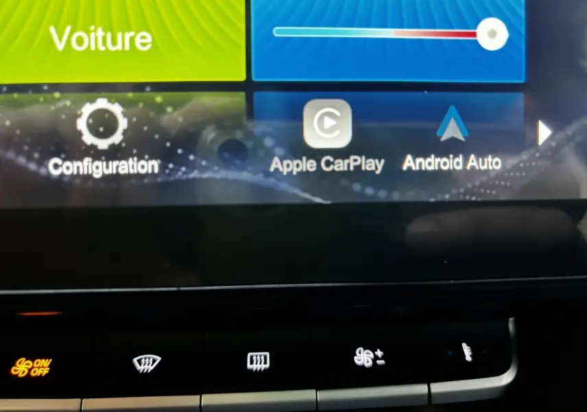 Gros plan sur l'écran tactile central du MG ZS 2022, affichant Apple CarPlay et Android Auto, avec commandes climatisation en dessous.