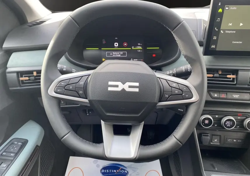 Vue intérieure centrée sur le volant multifonction noir et gris du Dacia Sandero Stepway avec tableau de bord digital et écran tactile.