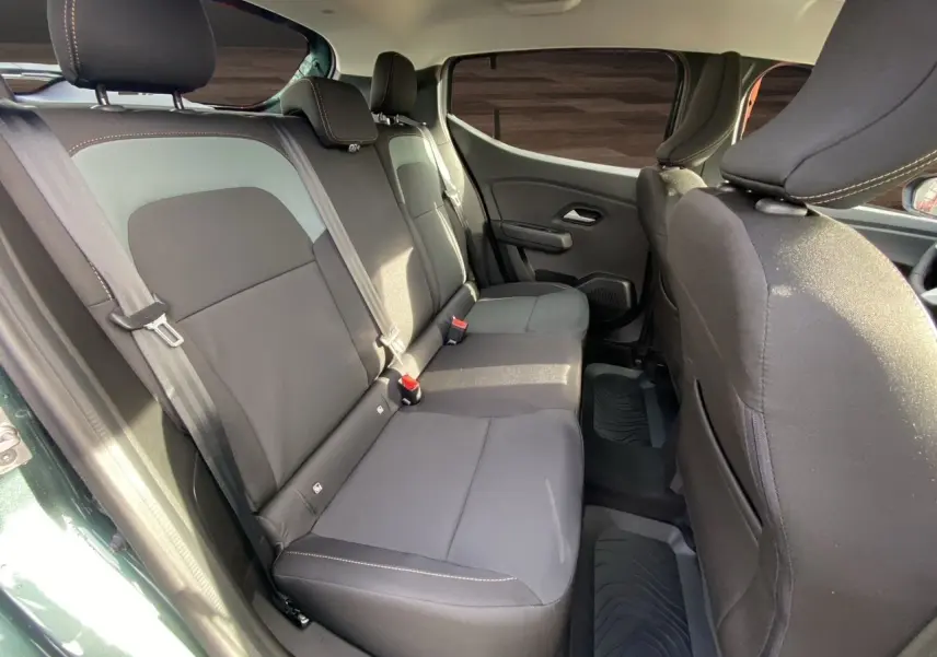 Vue intérieure sur les sièges arrière noirs et gris du Dacia Sandero Stepway 2026, avec porte ouverte côté gauche.