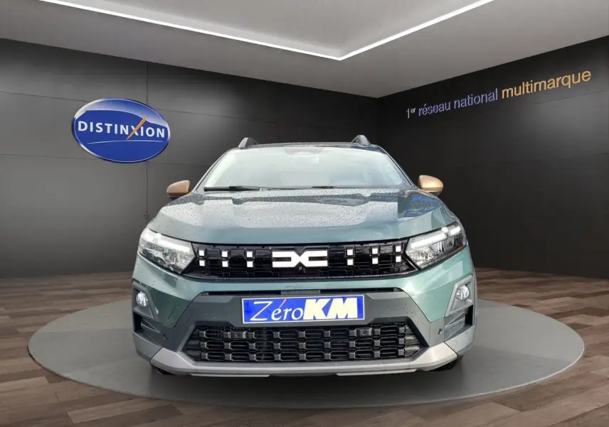 Vue frontale d'une Dacia Sandero Stepway 2026 vert cèdre avec calandre noire et logo DACIA lumineux.