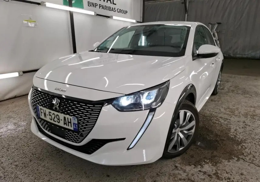 Peugeot 208 e-136 blanche vue 3/4 avant droit avec phares allumés et calandre noire brillante.