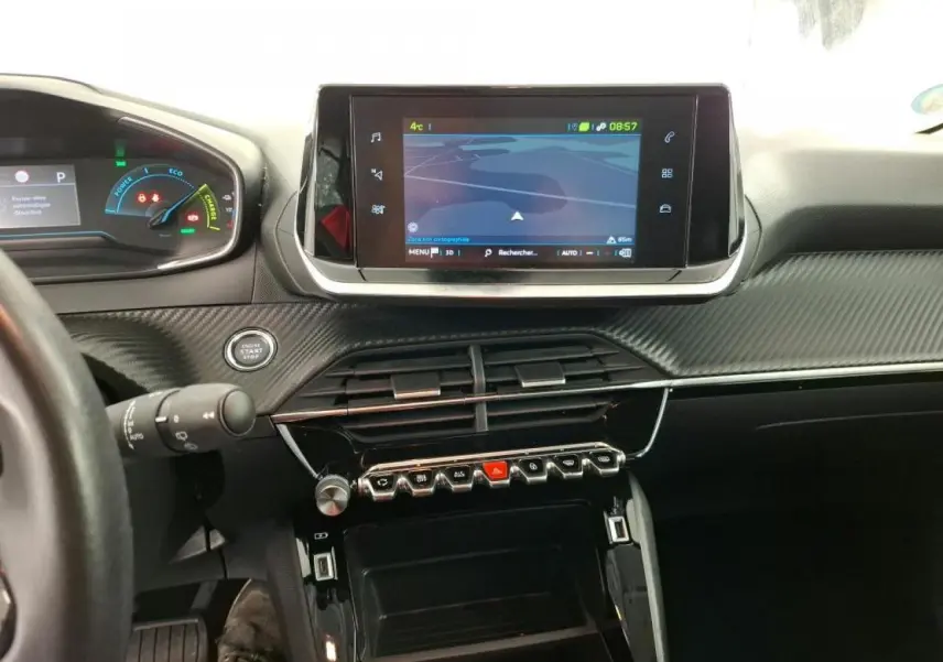 Vue intérieure centrée sur la console centrale et l'écran tactile du Peugeot 208 e-136 blanc, avec tableau de bord numérique.