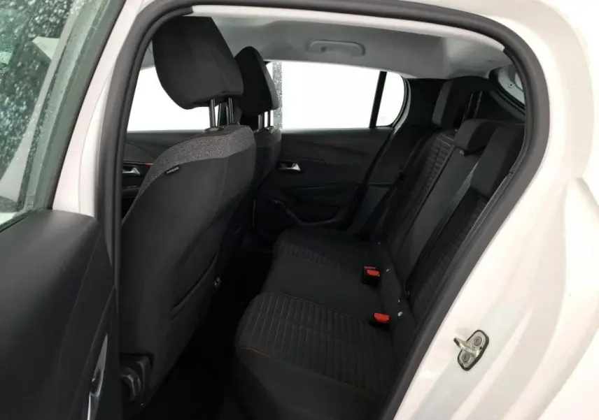Vue intérieure côté gauche sur la banquette arrière noire avec surpiqûres orange d'une Peugeot 208 blanche électrique 2020.