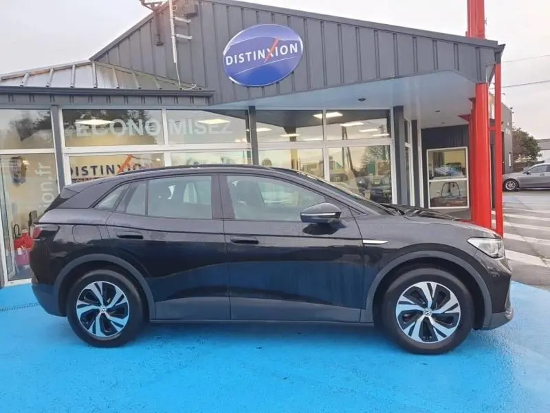Vue latérale droite du Volkswagen ID.4 148ch Pure noir Ebène métallisé, avec jantes alu et lignes épurées.