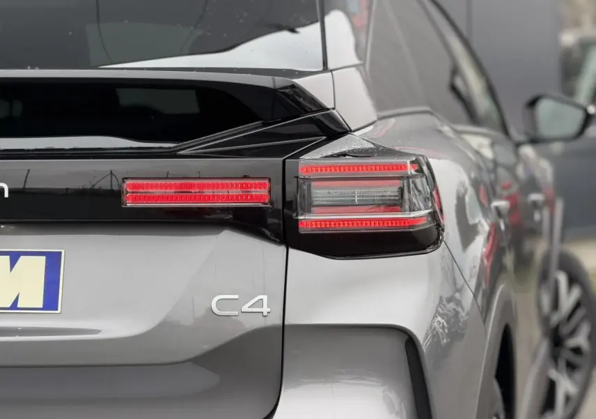 Vue arrière droite d'une Citroën C4 gris Mercury avec feux arrière LED et toit bi-ton noir Perla Nera.