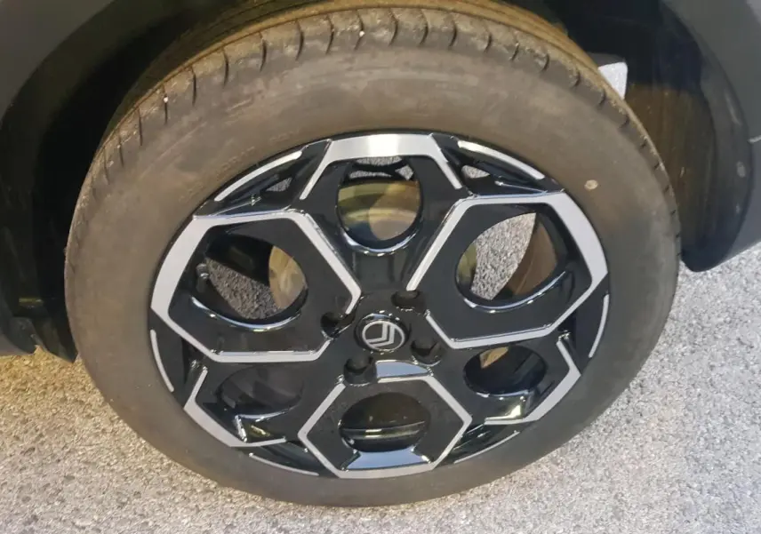 Gros plan sur la jante alliage 17 pouces noire et argentée du côté avant gauche d'une Citroën C3 noire.
