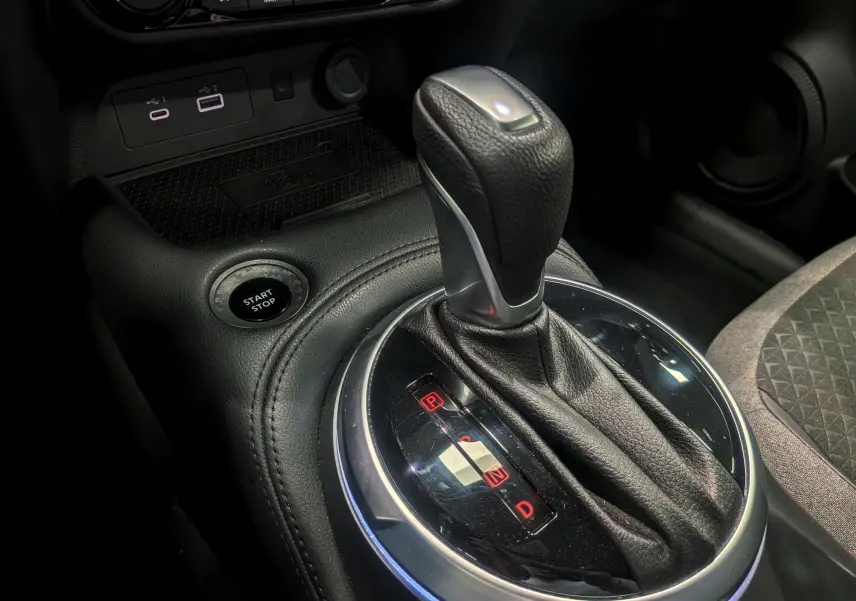 Gros plan sur le levier de vitesses automatique en cuir noir du Nissan Juke Hybrid 2025, avec bouton start/stop visible.